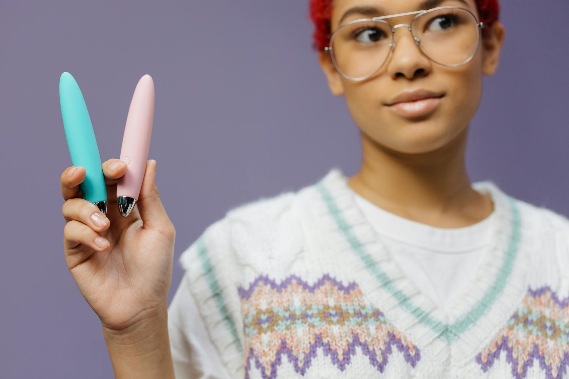 Woman holding vibrators, representing first-time pleasure exploration