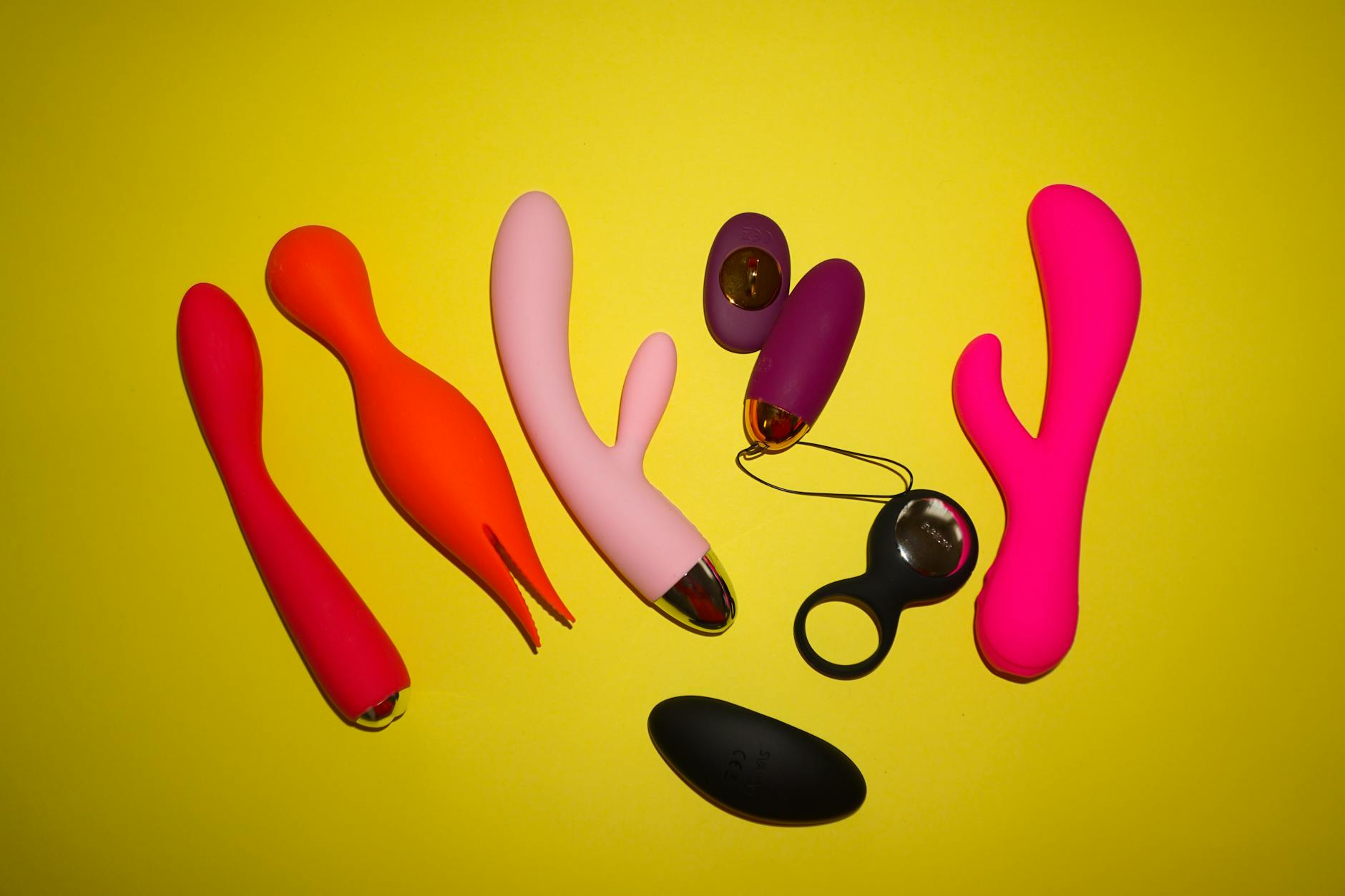 Studio con vibratori colorati su sfondo giallo vibrante, con diverse forme e design